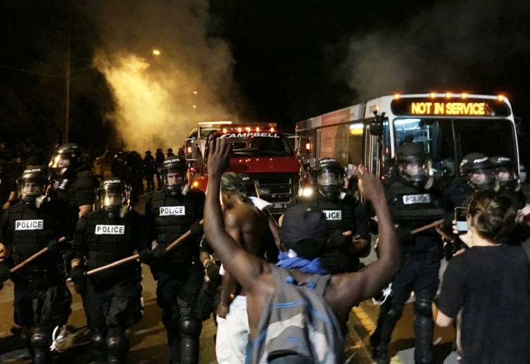 Police officers wearing riot gear block a road during protests after police fatally shot Keith Lamont Scott in the parking lot of an apartment complex in Charlotte, North Carolina, U.S. September 20, 2016. REUTERS/Adam Rhew/Charlotte Magazine   MANDATORY CREDIT. FOR EDITORIAL USE ONLY. NO RESALES. NO ARCHIVES.     TPX IMAGES OF THE DAY